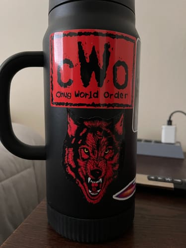 Customer's red and black custom vinyl stickers, featuring a wolf and text, on a black insulated mug.