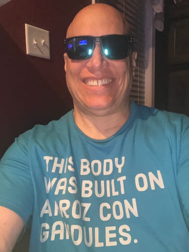 Reviewer smiling while wearing the 80Eighty Polarized Sunglasses with blue chrome lenses.