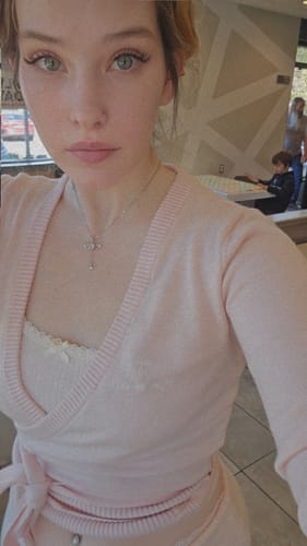 Reviewer showing the fit of the light pink Ballet Knit Wrap Cardigan in a selfie.