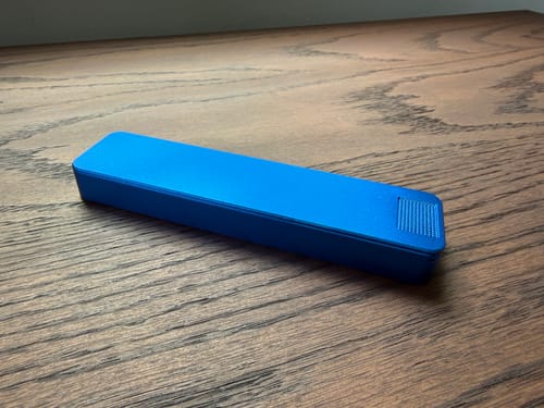 Customer's blue Weekly Case shown fully closed on a wooden surface.