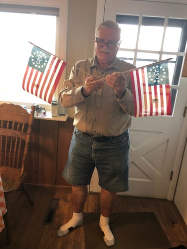 Reviewer holding two America 250 Betsy Ross Stick Flags indoors.