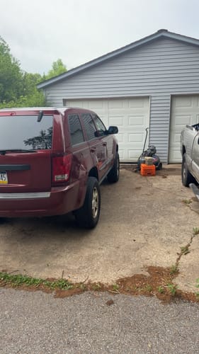 Customer's red Jeep Grand Cherokee with 2" wheel spacers installed, showing the rear wheel's extended position.