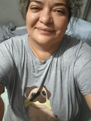Uma cliente vestindo a Camisola Pug cinza, mostrando o caimento solto do produto e a estampa de um cachorro pug.