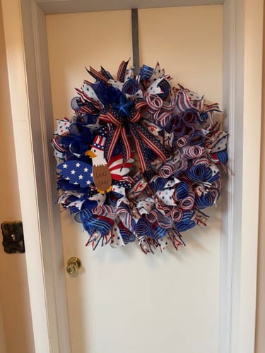 Reviewer's handmade patriotic wreath on a door, with an eagle sign attached using the mounting squares.