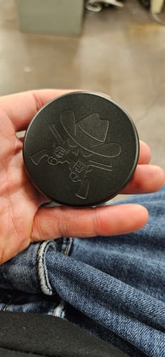 Customer holding a closed black custom tin with an embossed western design used to store nicotine pouches.