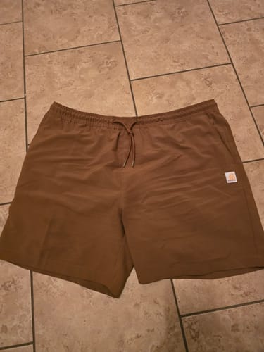 Customer's brown HeartCars Shorts with a drawstring waist laid flat on a tiled floor.