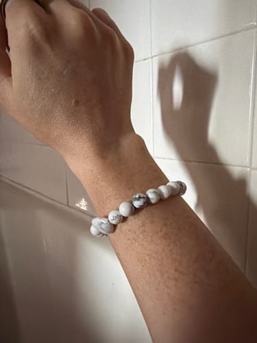 Customer's white and grey beaded howlite bracelet on their arm.