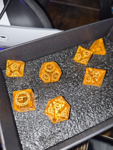 Customer's sparkly orange URWizards glass dice set displayed in its black box.