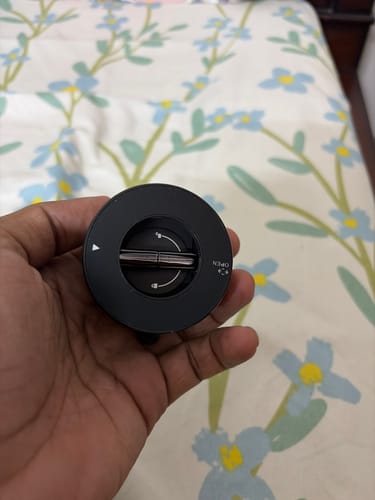 Customer holding the round, black 360° MagPro Magnetic Phone Holder in their hand, showing the rotation markings.
