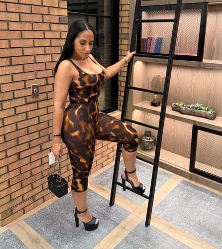 Reviewer posing in a form-fitting tortoise print Naked Print Scoop Tank Bodysuit with matching bottoms.