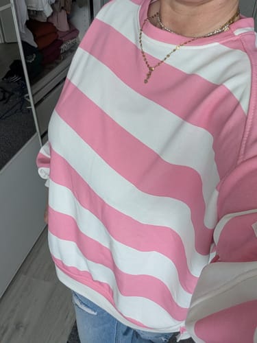 Rezensent trägt den übergroßen, rosa und weiß gestreiften Icon Sweater.