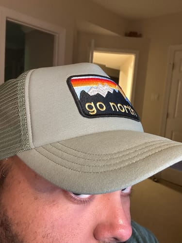 Close-up of a customer wearing the light green Big Foam Trucker Hat with a 'go north' patch.
