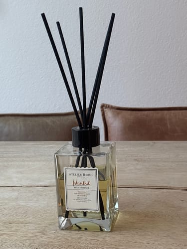 Recensent toont de Istanbul Geurstokjes op een houten tafel in huis.