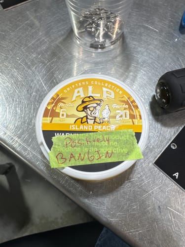 Customer's can of Drifters Island Peach Nicotine Pouches on a metal table with a handwritten positive note.