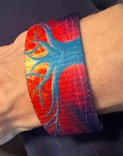 Reviewer wearing the vibrant Trust Your Path Bracelet, showing its colorful tree design on their wrist.