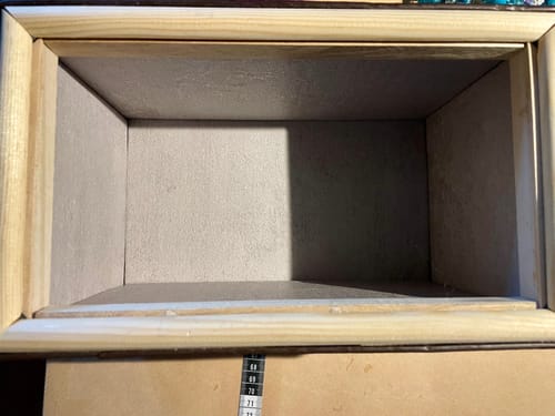 Nærbilde av innsiden av en boks kledd med lys grå Mikrosement kontaktplast.