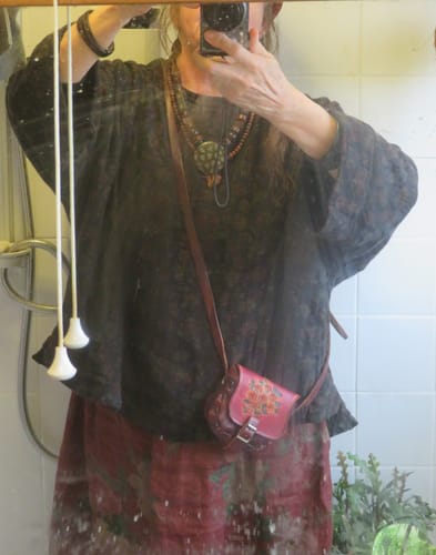Reviewer in a mirror selfie wearing the russet floral A-line skirt with a dark, billowy top.