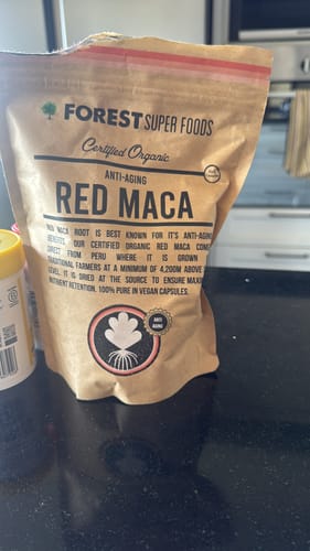 Customer's bag of Certified Organic Red Maca Root Capsules sitting on a black kitchen countertop.