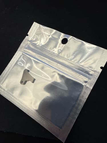 Customer's Taurus TX22 FRT trigger part shown inside its sealed, clear-fronted foil pouch.