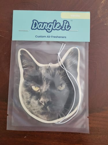 Customer's custom air freshener in its packaging, shaped like a cat's head with a photo of a black cat.