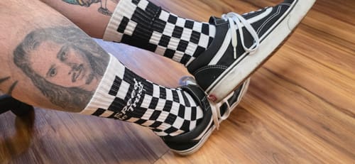 Reviewer wearing black and white CHECKERS CREW SOCKS with black sneakers.