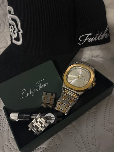 Customer's two-tone Lucky Fours® Brone watch in its green box with the included sizing tool and extra links.