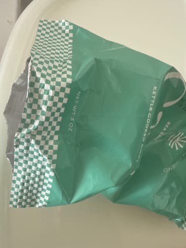 Customer's opened and crumpled green bag of CAVI's Kettle Cooked Sea Salt Chips.