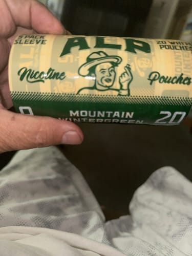 Customer holding a green 5-pack sleeve of Mountain Wintergreen Nicotine Pouches.