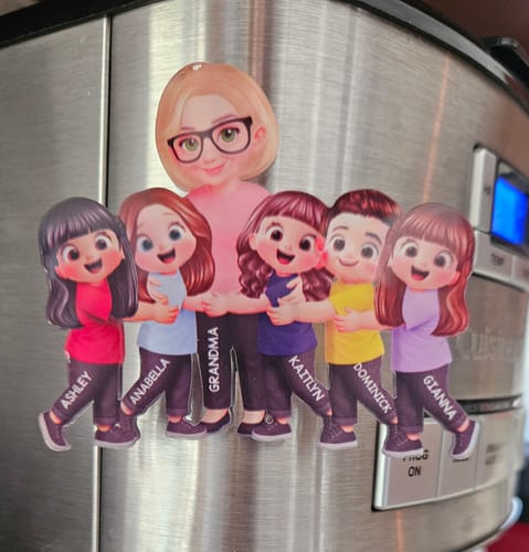 Customer's personalized acrylic magnet of a grandma character and five grandkids hugging, attached to a fridge.