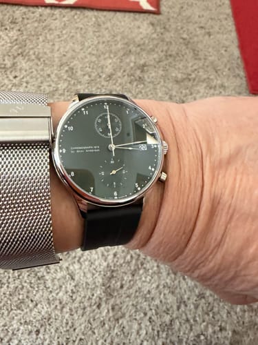 A reviewer's wrist showing the black Channel Rubber strap on a chronograph watch.