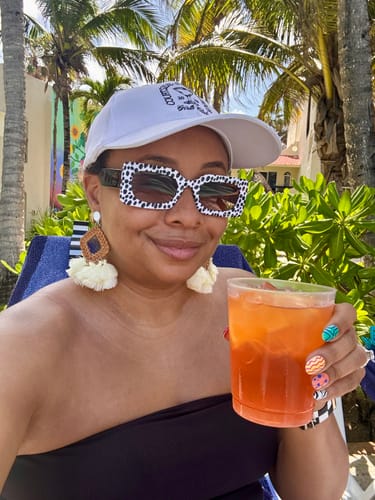 Reviewer smiling outdoors, wearing the spotted Maximalist Mixed Print Sunnies.