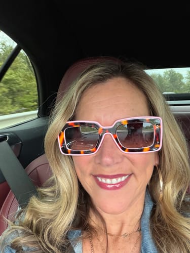 Customer in a car wearing the Deco Sunglasses with a bold, color-block pattern.
