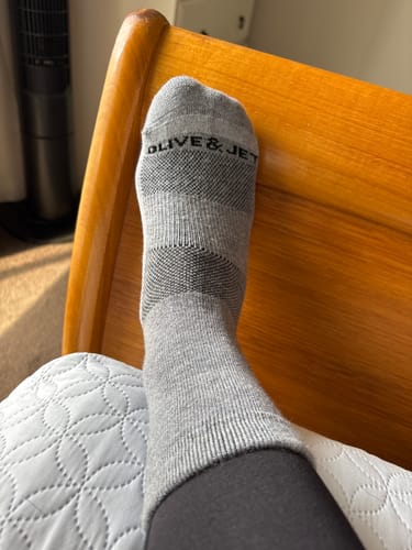 Customer's foot wearing the grey Quarter Sock, showing the detailed knit pattern.