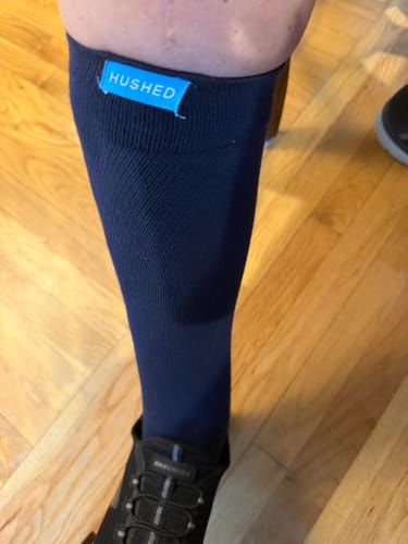 Customer wearing the knee-high, dark blue Eucalyptus Lyocell Compression Socks with a black sneaker.