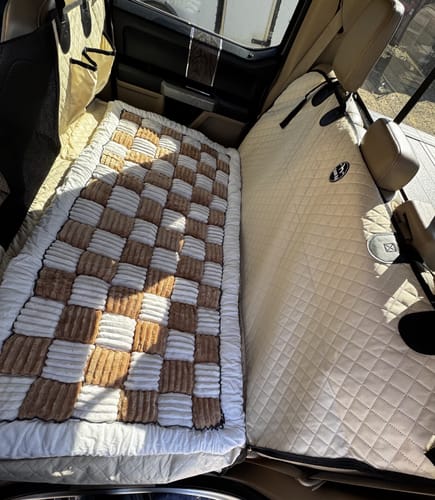 Customer's quilted hammock cover installed in the back of a truck, viewed from above with a blanket on top.