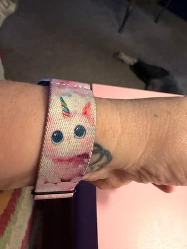 Reviewer showing a colorful, cute unicorn-print watchband on their wrist.
