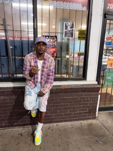 Reviewer standing outside a store wearing the Vale Forever Piggy Bank Flannel in pink over a white shirt.
