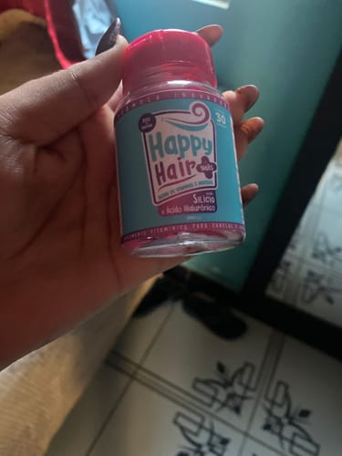 Cliente segurando um pote do suplemento Happy Hair.