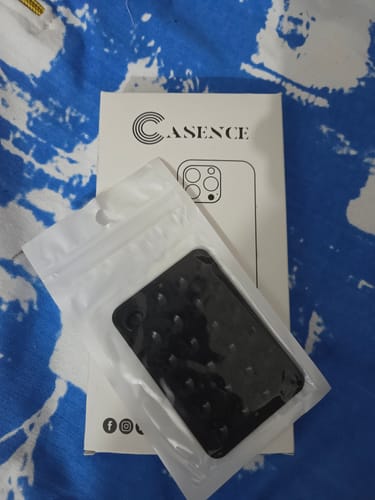 Customer's black StickyPod in its clear packaging, with the product box behind it.