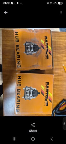 Customer's two orange Partquip boxes for the Wheel Bearing Kit sitting on a wooden table.