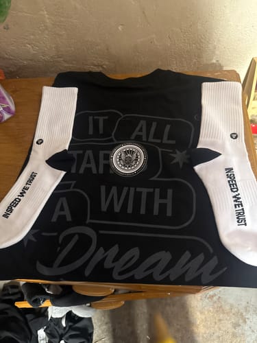 Customer's black MYSTERY TEE with 'IT ALL STARTED WITH A Dream' text, shown with socks and a patch.