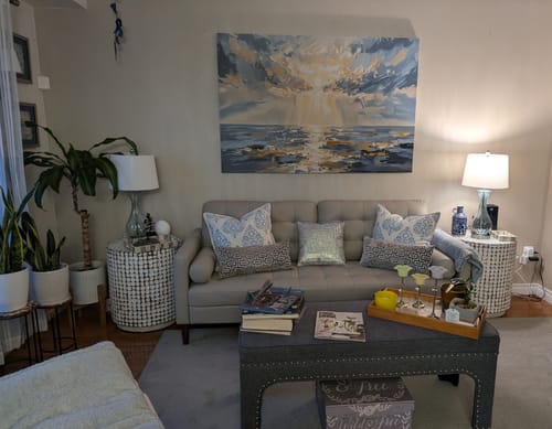 Customer's 'When Light Breaks Through' canvas art hung in their living room above a grey tufted sofa.