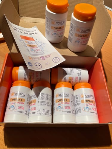Recensore mostra la sua scorta di integratori Agolab OMEGA 3 TRIACTION in una scatola aperta.
