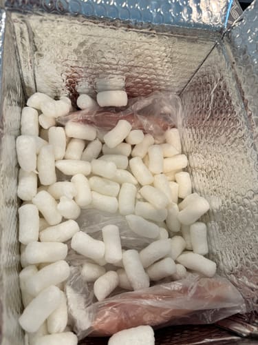 Reviewer's view inside an insulated box showing packing peanuts protecting the delivered chicken.