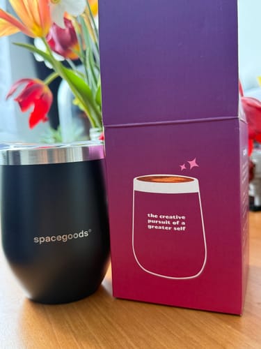 Reviewer's black insulated cup with the 'spacegoods' logo, shown next to its purple product box.