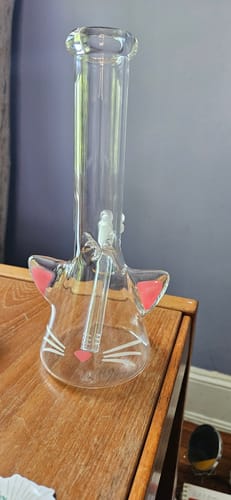Customer's clear Kitty Cat Glass Beaker Bong sitting upright on a wooden dresser, showing the pink and white face details.