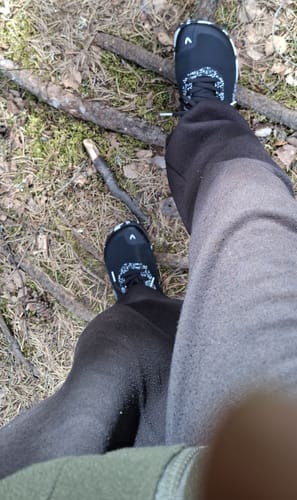 Arvostelijan Vaistoa Lento -paljasjalkajuoksukengät jalassa metsäisessä maastossa.
