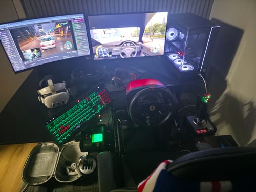 Customer's complete gaming simulator setup, featuring a racing wheel, joystick, and dual monitors.