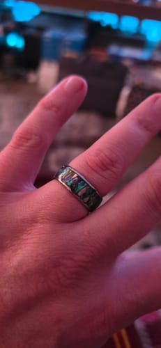 Customer wearing the Nerium ring on their finger, showing its iridescent abalone inlay.