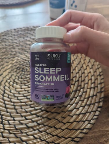 Un client tient dans sa main le flacon de jujubes Suku Sommeil Réparateur.